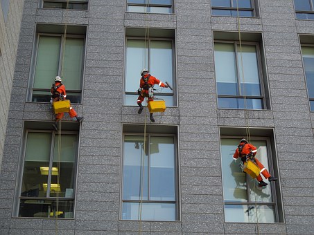 men cleaning building's window